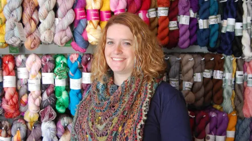 Rebecca Smith in front of yarn selection