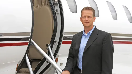 Don Chupp posing at the entrance of a private jet.
