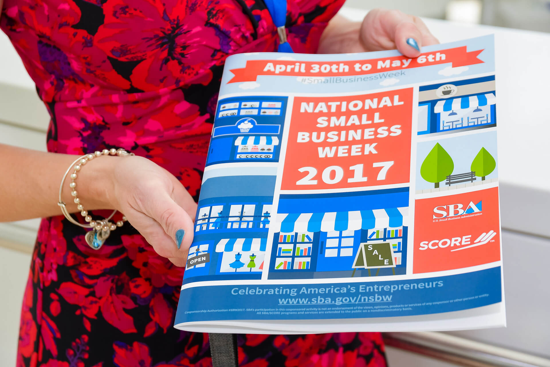 Woman holding brochure from National Small Business Week 2017.