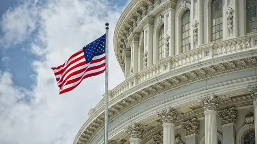 Bandera de Estados Unidos ondea frente a la cúpula del Capitolio