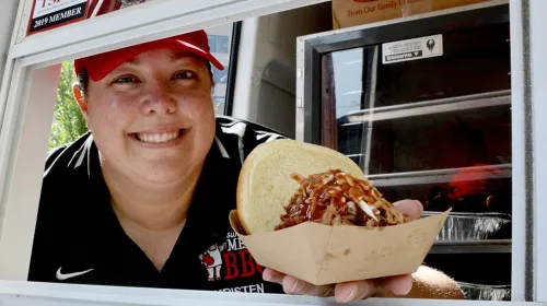 Image of Kristen Bailey holding a BBQ sandwhich