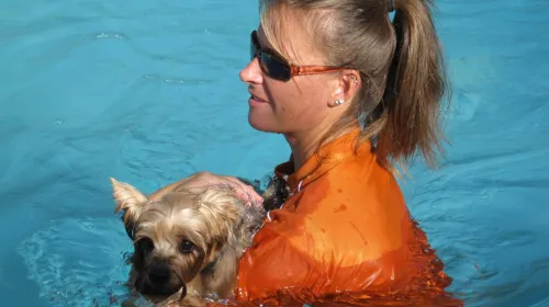 Image of Kim Novak swimming with a small dog