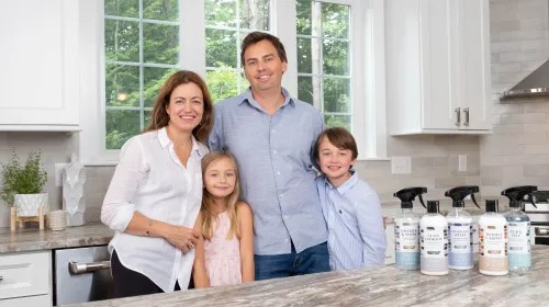 A picture of Anne Ruozzi with her husband and two children, all smiling next to Therapy Clean products.