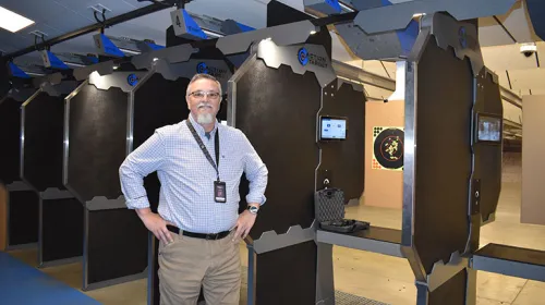 Business owner proudly standing by their indoor shooting range