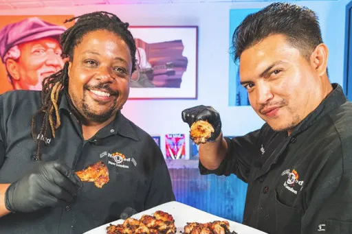 Rod Cornish and Chef Carlos holding a plate of wings