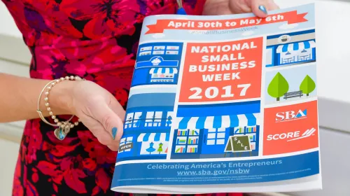 Woman holding brochure from National Small Business Week 2017.