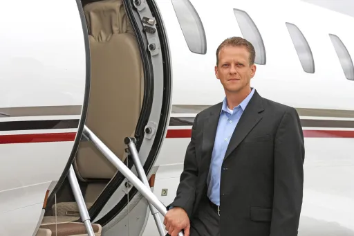 Don Chupp posing at the entrance of a private jet.